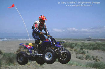 All Terrain Vehicle (ATV) in mid air while riding in the Samoa Dunes, near Eureka, California