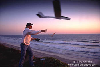 Launching a radio controlled glider into the wind above the Pacific Ocean at sunset, Carlsbad, San Diego County, California Coast