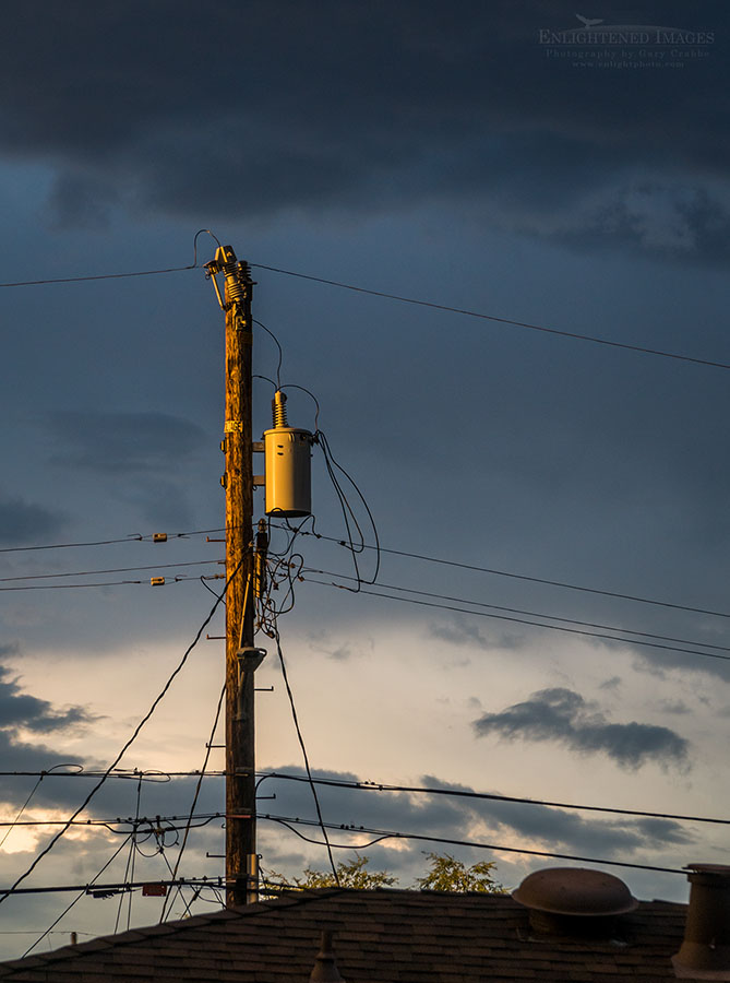 Photo: Stormy sunset light on electrical transformer box and telephone poles, Pleasant Hill, California