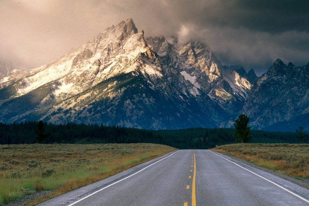 Photo picture of Straight road with passing lane below mountain range dusted by first snow storm of fall, Grand Teton National Park, WYOMING