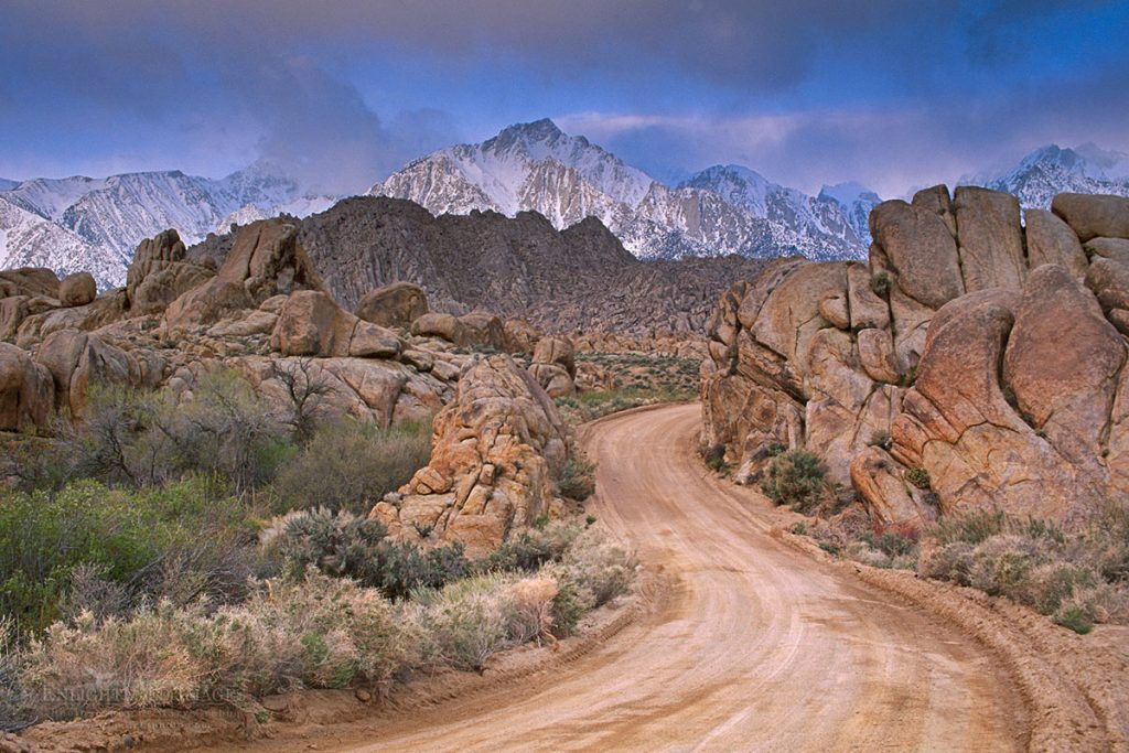 Photo picture of Twisting dirt road below mountain peak in the Eastern Sierra during a spring snow storm, Alabama Hills near Lone Pine, Inyo County, California