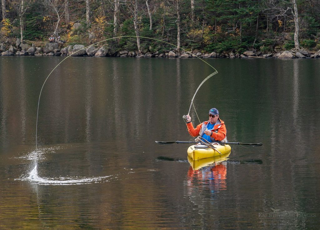 Photo Picture of Fisherman fly-fishing from a kayak in a New England lake, White Mountain National Forest, New Hampshire