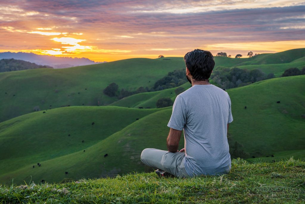 Photo picture of Person enjoying the bliss of watching the sunset over rolling green hills in spring, Briones Regional Park, Contra Costa County, California