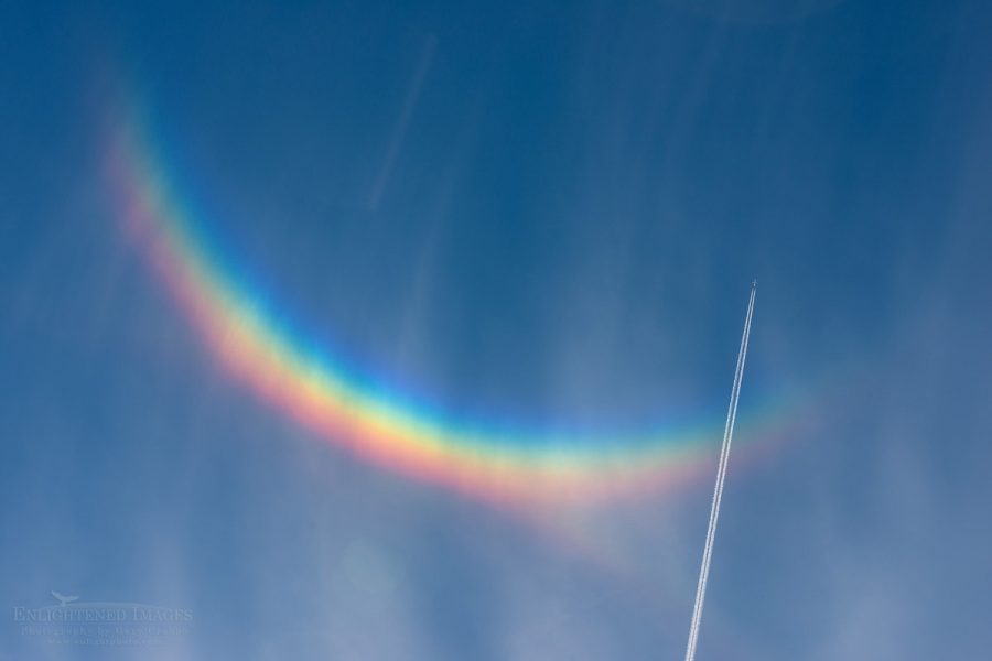 Photo pictures of Jet airplane with contrail flying through high cirrus clouds and a circumzenithal arc